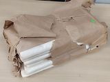 a brown paper bag that has a bunch of folded towels on it