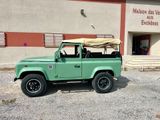 a green land rover parked outside of a building