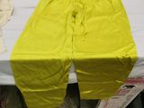 a bed with a yellow sheet on it and a pair of gloves on the bed