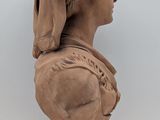 an image of a clay bust of a woman with a turban on her head