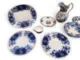 several pieces of blue and white dishes and a pitcher on a white surface