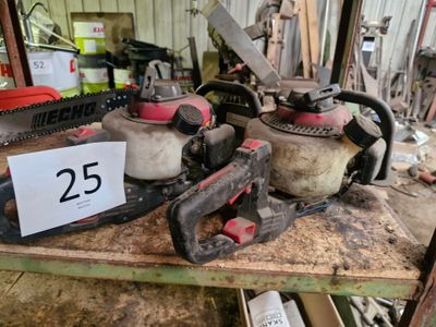 deux tronçonneuses posées sur une table dans un garage