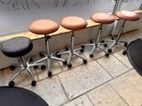 several stools are lined up against a wall with writing on the wall