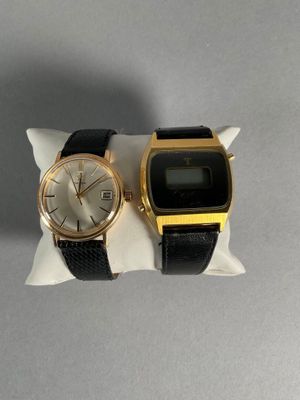two watches sitting on a pillow on a table