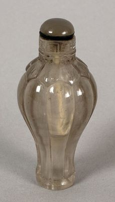 a small glass bottle with a silver lid on a table