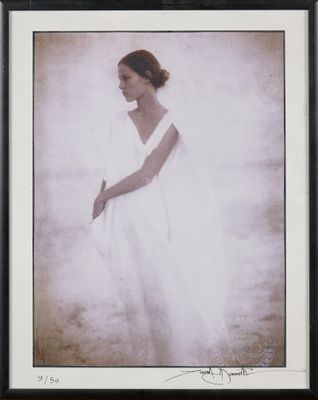 an old photo of a woman in a white dress in a black frame