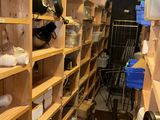a room with a lot of wooden shelves with pots and pans on them