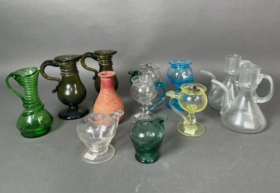 de nombreux vases et verres en verre de différentes couleurs sur la table