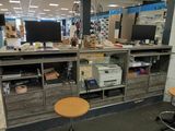 a desk with a computer monitor and a printer on it