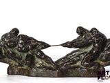 a bronze sculpture of two men wrestling each other