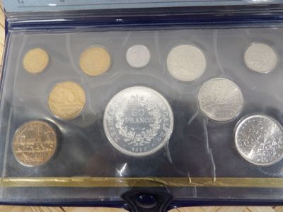 an assortment of coins in a case sitting on a table
