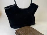 a black purse and a book sitting on a table