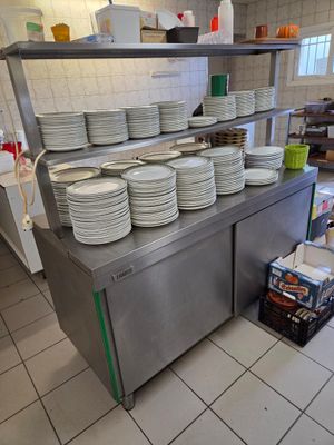 de nombreuses assiettes empilées sur le plan de travail de la cuisine