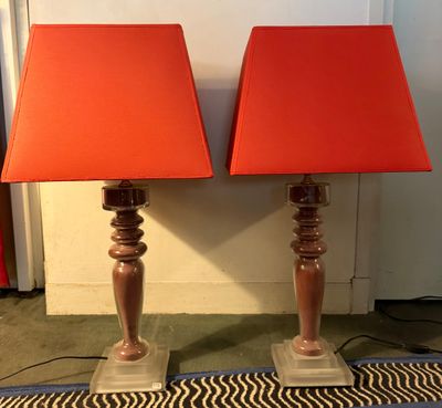 une paire de lampes orange avec des abat-jours rouges, posées sur un tapis
