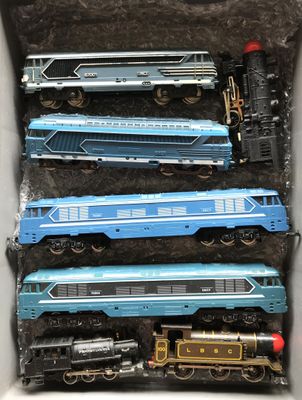 quatre trains bleus dans une boîte posée sur la table