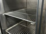 an empty stainless steel refrigerator with shelves in it