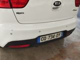 the rear end of a white car parked in a garage