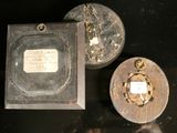 a small metal box with a small metal object in it