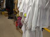 beaucoup de vêtements suspendus à une étagère dans une pièce