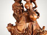 an image of a wooden statue of a man with a pot on his shoulder