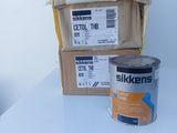 a can of paint on a table next to a stack of boxes