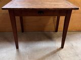 une vieille table en bois avec un tiroir en dessous, dans une pièce