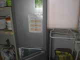 a refrigerator and a trash can in a small room