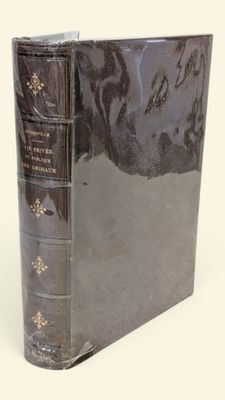 un vieux livre à la couverture noire posé sur une table blanche