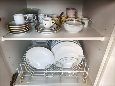 de nombreux plats et tasses sur les étagères du placard