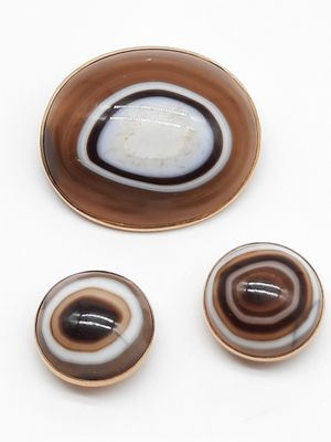 trois morceaux de verre marron et blanc posés sur une surface blanche