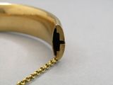 une photo en gros plan d'un bracelet en or muni d'une chaîne