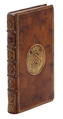 un vieux livre relié en cuir, orné d'un médaillon doré sur la couverture