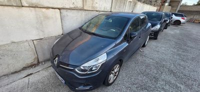 the blue car is parked in a parking lot next to a wall