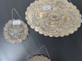 three silver metal trays on a table with tags on them