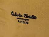 the back of a yellow shirt with a black logo on it
