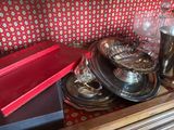 de nombreux plats et tasses en argent posés sur une table en bois