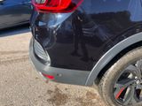 a close up of a black car parked in a parking lot