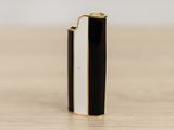 a black and white lighter sitting on top of a wooden table
