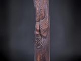 une statue en bois représentant un homme tenant un panier de fruits