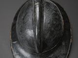 a close up of a metal helmet on a gray surface