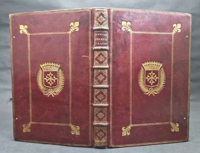 un vieux livre à la couverture rouge ornée de motifs dorés