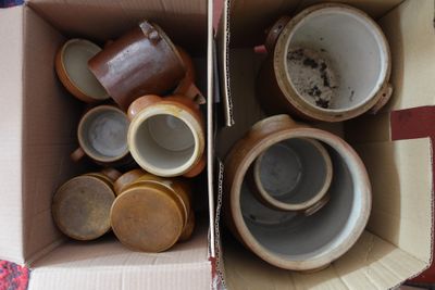 une boîte en carton remplie de nombreuses tasses de toutes sortes