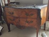 une commode en bois avec un plateau en marbre dans une chambre