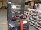 a fork lift truck in a warehouse with pallets of pallets in the background