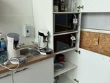 a small kitchen with a microwave, sink, and cabinets