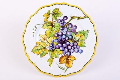 a plate with a bunch of grapes painted on it