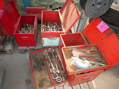 beaucoup d'outils dans une caisse rouge posée par terre