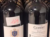 several bottles of wine are lined up on a shelf in a store
