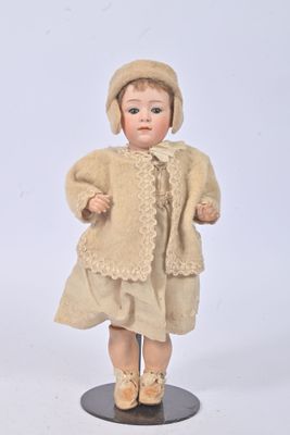 a small doll that is wearing a dress and hat