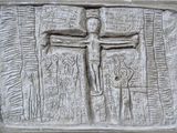 relief représentant un homme sur une croix, sur un mur d'une église
